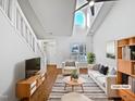 Bright living room with high ceilings, modern furnishings, and large windows at 8209 Rolling Glenn Dr, Raleigh, NC 27616