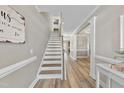Bright foyer with staircase and wood flooring, leading to open living spaces at 917 Sequoia Ridge Dr, Fuquay Varina, NC 27526