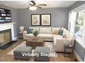 Bright living room featuring hardwood floors, a cozy fireplace, and large windows for natural light at 136 Dogwood Trl, Wendell, NC 27591
