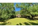 Charming brick ranch-style home with a well-manicured lawn and mature trees offering shade and curb appeal at 2118 N Woodland Rd, Henderson, NC 27536