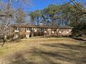 Spacious brick home with a large front yard, mature trees, and traditional architecture, creating a stately appearance at 2118 N Woodland Rd, Henderson, NC 27536