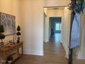 Inviting foyer with hardwood floors, artwork, and a decorative table displaying homey accents and an open entry way at 244 Bevis Marks Dr, Fuquay Varina, NC 27526