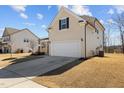 Beige two-story home with a two-car garage, situated on a well-maintained lawn under a partly cloudy sky at 40 Glendavis Hollow Dr, Franklinton, NC 27525