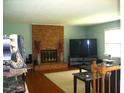Cozy living room featuring a brick fireplace, hardwood floors, and natural light at 4408 Leota Dr, Raleigh, NC 27603