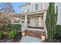 Inviting front porch with brick steps, painted columns, and stylish front door at 504 Crooked Pine Dr, Cary, NC 27519