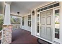 Inviting front porch with brick details, a painted column, and a stylish gray front door at 504 Crooked Pine Dr, Cary, NC 27519