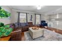 Inviting living room with hardwood floors, comfortable seating, and ample natural light from the large windows at 5412 Farley Dr, Raleigh, NC 27609