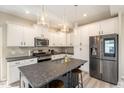Modern kitchen with white cabinets, stainless steel appliances, and a gray granite island at 5439 Ripplebrook Rd, Durham, NC 27712