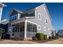 View of the screened porch, well-maintained landscaping and gray siding at 5501 Advancing Ave, Raleigh, NC 27616