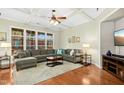 Bright living room with hardwood floors, coffered ceilings, large sectional sofa and ample natural light at 6103 Leesburg Ln, Raleigh, NC 27617