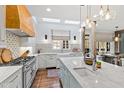 Bright kitchen featuring an island, farmhouse sink, professional gas range, and custom lighting at 6532 Wakefalls Dr, Wake Forest, NC 27587