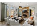 Cozy living room with stone fireplace, large windows, and elegant seating arrangement at 6532 Wakefalls Dr, Wake Forest, NC 27587