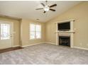 Bright living room featuring plush carpet, a fireplace, and a ceiling fan, creating a welcoming atmosphere at 66 Shetland Ln, Smithfield, NC 27577