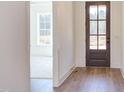 Bright entryway with a hardwood floor and a stylish, paneled front door leading into a carpeted bedroom at 75 Harvest View Way, Franklinton, NC 27525