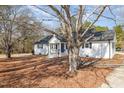 Quaint single story with white painted brick, black shutters, and fresh landscaping at 7722 Nc 27 W, Lillington, NC 27546