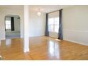 Bright living area featuring gleaming hardwood floors, a modern chandelier, and neutral walls at 8 Weeping Beech Way, Durham, NC 27713