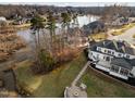 Beautiful backyard with stone patio and fire pit sitting on a lush green lawn near a tranquil lake at 1326 Lochshire Dr, Burlington, NC 27215