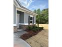 The exterior detail shows manicured landscaping with vibrant red flowers and brick foundation at 135 Baneberry Dr, Broadway, NC 27505