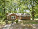 Charming brick ranch-style home with mature trees and a well-maintained front lawn at 1411 Rosewood St, Durham, NC 27701