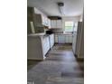 This kitchen features white appliances, white cabinets, light countertops, and wood look floors at 1440 Collegeview Ave # 301, Raleigh, NC 27606