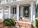 Inviting front porch featuring classic columns, charming decor, and a cozy seating area at 1617 Heritage Club Ave, Wake Forest, NC 27587