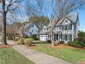 Lovely two-story home with a manicured lawn, sidewalk, and beautiful trees lining the street at 1617 Heritage Club Ave, Wake Forest, NC 27587