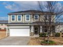 Charming two-story home boasts a two-car garage, welcoming front porch, and mature landscaping at 2000 Muddy Creek Ct, Raleigh, NC 27610