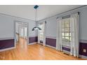 Bright dining room offers hardwood floors, large windows, natural light and neutral color palette at 2001 Carrington Dr, Raleigh, NC 27615