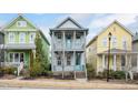 Charming two-story house with a inviting front porch and vibrant turquoise doors, nestled between colorful homes at 2098 Great Ridge Pkwy, Chapel Hill, NC 27516
