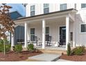 Inviting front porch with rocking chairs and swing, perfect for relaxing and enjoying the outdoors at 2534 Great Daisy Ln, New Hill, NC 27562