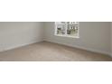 Cozy bedroom with neutral carpet, white trim, and a bright window overlooking the neighborhood at 273 Umstead St, Sanford, NC 27330