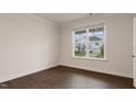 Bedroom with hardwood floors, a large window with neighborhood views, and white trim at 277 Umstead St, Sanford, NC 27330