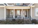 Inviting front porch features rocking chairs, brick steps and columns, creating a cozy entrance at 29 Alban Row, Fuquay Varina, NC 27526