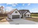 A modern white farmhouse-style home with dark trim, gray roof, and large concrete driveway at 2955 Mt Pleasant Rd, Willow Springs, NC 27592