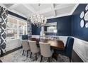 Formal dining room with coffered ceilings, large windows, and a stylish chandelier at 308 Harmony Creek Pl, Apex, NC 27539