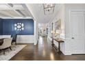 Inviting foyer featuring hardwood floors, elegant lighting, and wainscoting at 308 Harmony Creek Pl, Apex, NC 27539