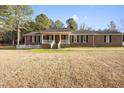 Charming red brick home featuring a welcoming front porch and a well-manicured lawn at 41 E T Hanner Rd, Bear Creek, NC 27207