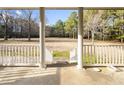 Spacious covered porch with white railings, offering serene views of the wooded yard at 41 E T Hanner Rd, Bear Creek, NC 27207