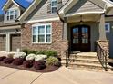 A cozy entrance featuring beautiful double doors, stone steps, and colorful flowerbeds at 429 Teague St, Wake Forest, NC 27587