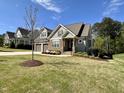 Inviting home with stone accents, a manicured lawn, and a welcoming front porch at 429 Teague St, Wake Forest, NC 27587