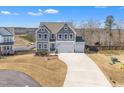 Two-story home with a three-car garage, neutral siding, and a long driveway at 492 Arlie Ln, Lillington, NC 27546