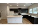 Modern kitchen with dark cabinets, stainless steel appliances, and center island with white countertop at 5004 Cambrey Dr # 3, Durham, NC 27703