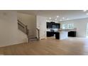 Open-concept living space with wood floors that flows into the kitchen and staircase to the second floor at 5004 Cambrey Dr # 3, Durham, NC 27703