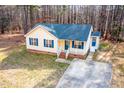 Aerial view of yellow house featuring blue shutters, brick foundation, and a concrete driveway at 5748 Presentation St, Knightdale, NC 27545