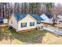 Aerial view of a yellow home with blue shutters, a well-kept lawn and proximity to other houses at 5748 Presentation St, Knightdale, NC 27545