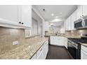 Bright kitchen features granite countertops, stainless steel appliances, and white cabinets at 684 Wickham Ridge Rd, Apex, NC 27539