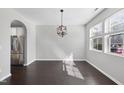 Sunlit living room featuring hardwood floors, neutral walls, and geometric pendant lighting at 684 Wickham Ridge Rd, Apex, NC 27539