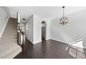 Bright living room with hardwood floors, staircase, and modern light fixture at 684 Wickham Ridge Rd, Apex, NC 27539