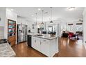 Modern, open-concept kitchen with stainless steel appliances, granite countertops, and a kitchen island at 7525 Poplar Meadow Ln, Raleigh, NC 27616