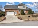 Brick house with a two-car garage, a long driveway, and landscaping at 7800 Twin Pines Way, Fuquay Varina, NC 27526